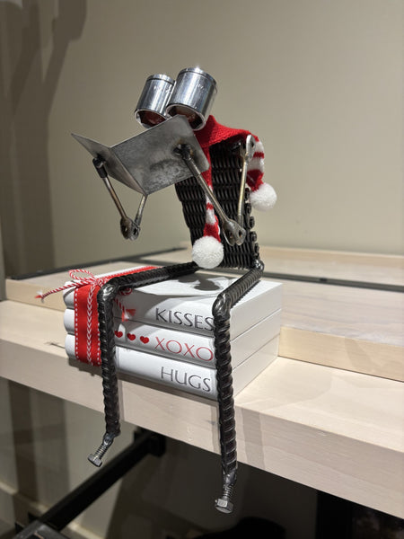 Kisses & Hugs Love Story Bot by R. Nelson features a reading robot sitting on stack of books.