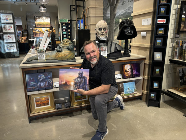 Artist Monte Moore with his collection of Mandalorian fine art canvas prints.